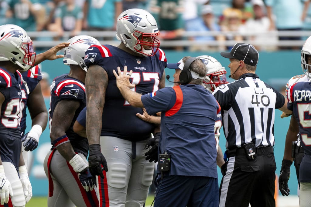 New England Patriots head coach Bill Belichick holds back New England Patriots offensive lineman Trent Brown (77) from joining a scuffle between players on the field during an NFL football game against the Miami Dolphins, Sunday, Oct. 29, 2023, in Miami Gardens, Fla. (AP Photo/Doug Murray)