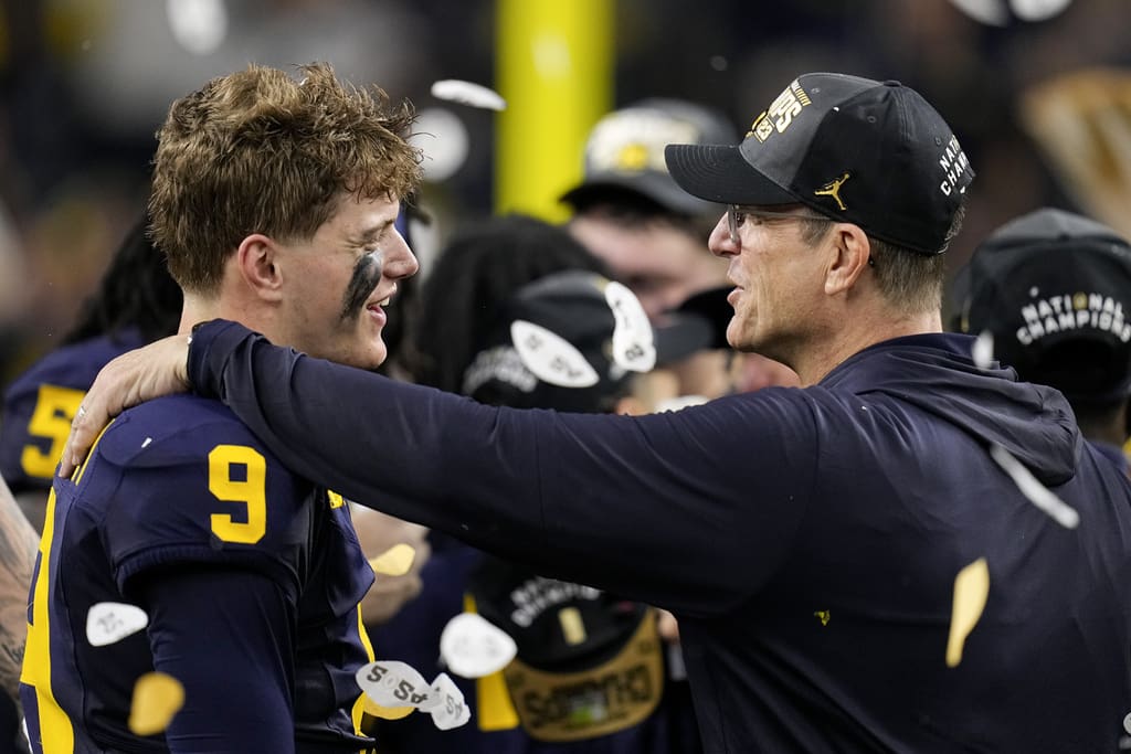 Michigan quarterback J.J. McCarthy celebrates their win with head coach Jim Harbaugh against Washington in the national championship NCAA College Football Playoff game Monday, Jan. 8, 2024, in Houston.Could either end up with the New England Patriots next season? (AP Photo/Eric Gay)