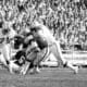 Quarterback Ken Stabler of the Oakland Raiders is sacked behind the lines by Julius Adams (85) of the New England Patriots in the first period of National Football League Playoff Game on Saturday, Dec. 18, 1976 in Oakland. Moving in at left is Ray Hamilton of the Patriots. (AP Photo)