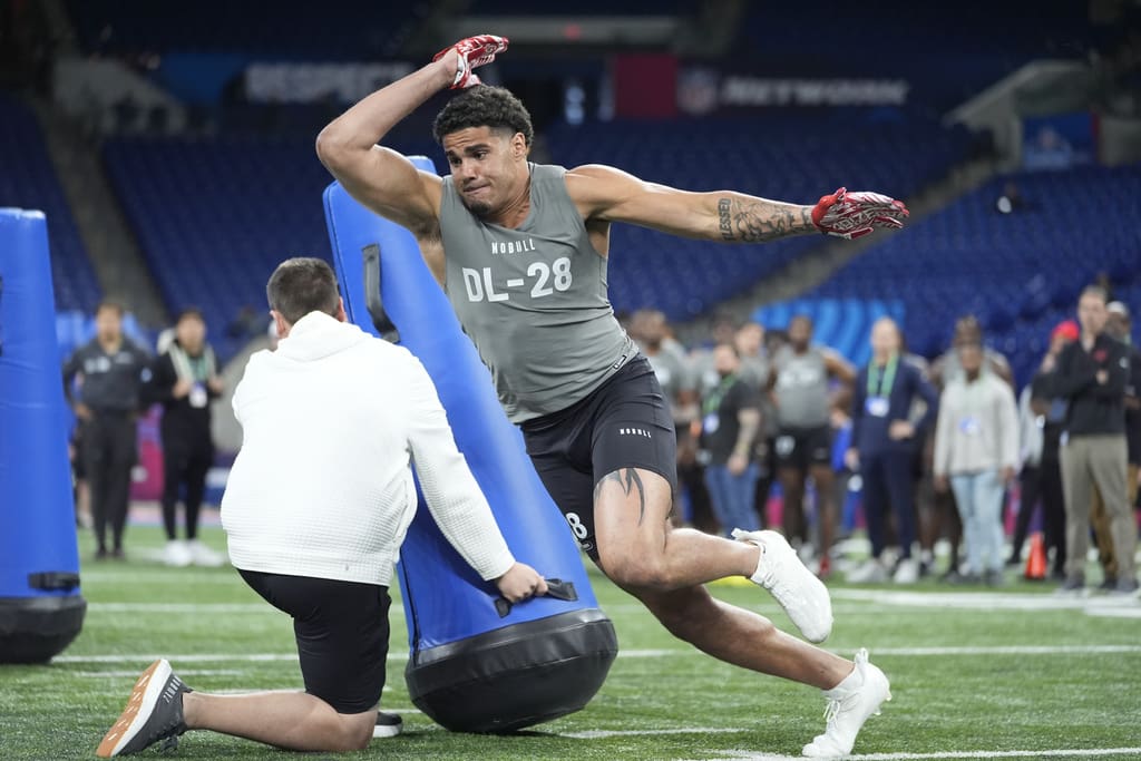 Kansas defensive lineman Austin Booker runs a drill at the NFL football scouting combine, Thursday, Feb. 29, 2024, in Indianapolis. (AP Photo/Michael Conroy)