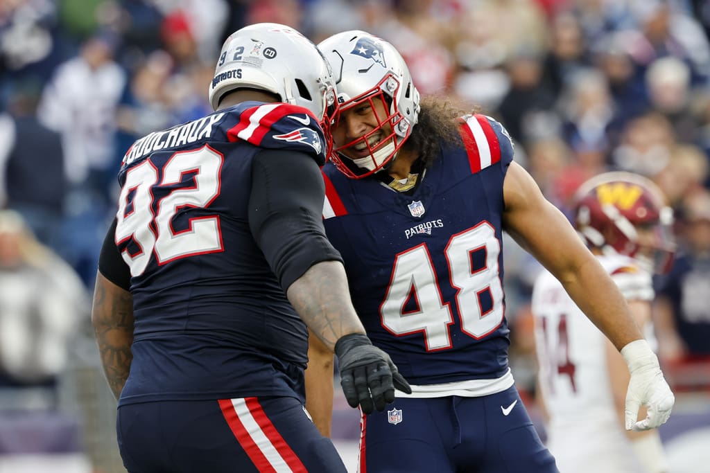 New England Patriots defensive tackle Davon Godchaux (92) celebrates with line backer Jahlani Tavai (48) after a stop during the second half an NFL football game against the Washington Commanders on Sunday, Nov. 5, 2023, in Foxborough, Mass. (AP Photo/Greg M. Cooper)