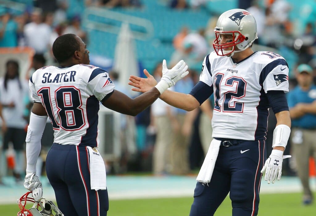 New England Patriots quarterback Tom Brady (12) greets wide receiver Matthew Slater (18) on the field before an NFL football game against the Miami Dolphins, Sunday, Jan. 3, 2016 in Miami Gardens, Fla. (AP Photo/Lynne Sladky)