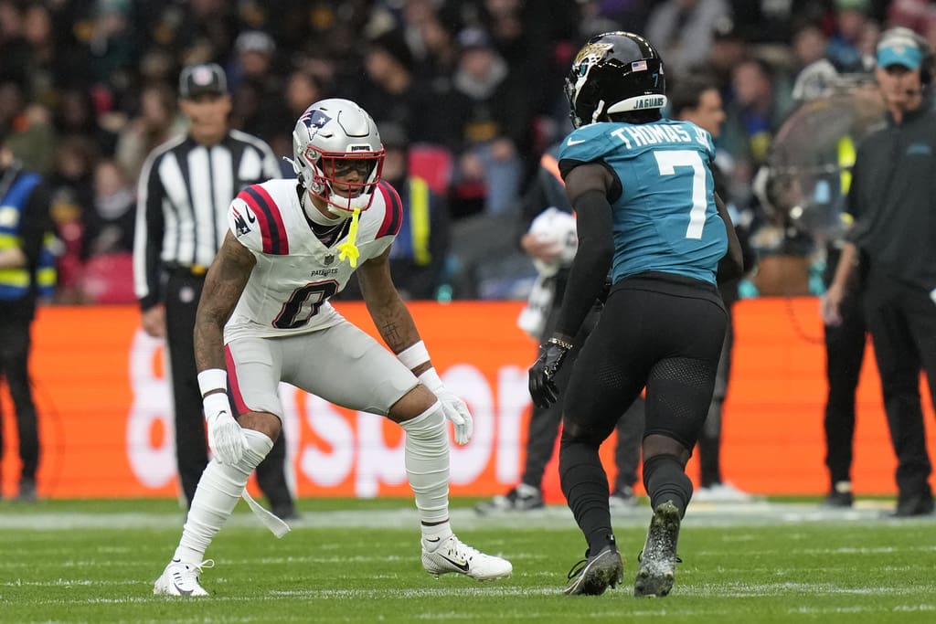 New England Patriots cornerback Christian Gonzalez (0) in coverage against Jacksonville Jaguars wide receiver Brian Thomas Jr. (7) during an NFL football game at Wembley Stadium, Sunday, Oct. 20, 2024, in London. (AP Photo/Steve Luciano)